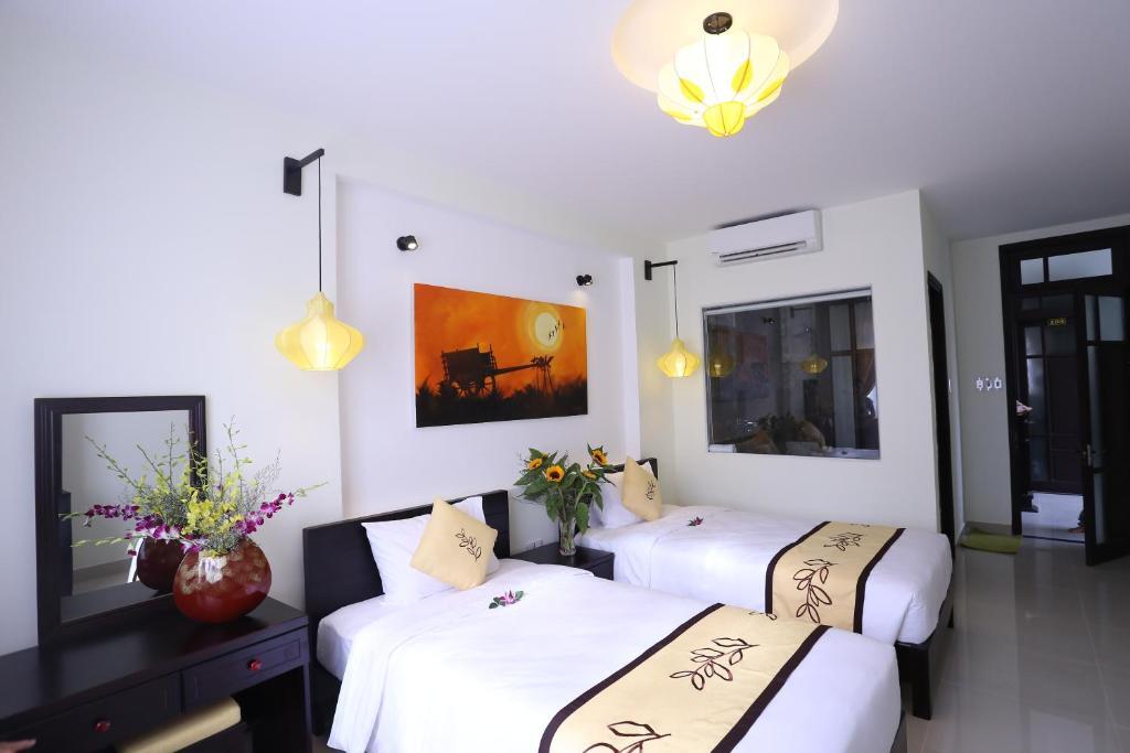 Кровать в общем номере с красивым видом из окна в Hoi An Cottage Villa