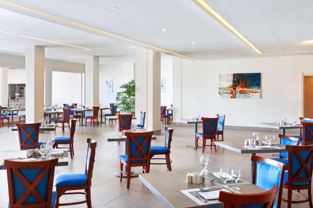 Pickalbatros Royal Grand Sharm - Adults Friendly 16 Years Plus: Bright dining room with neatly set tables and blue-accented chairs.