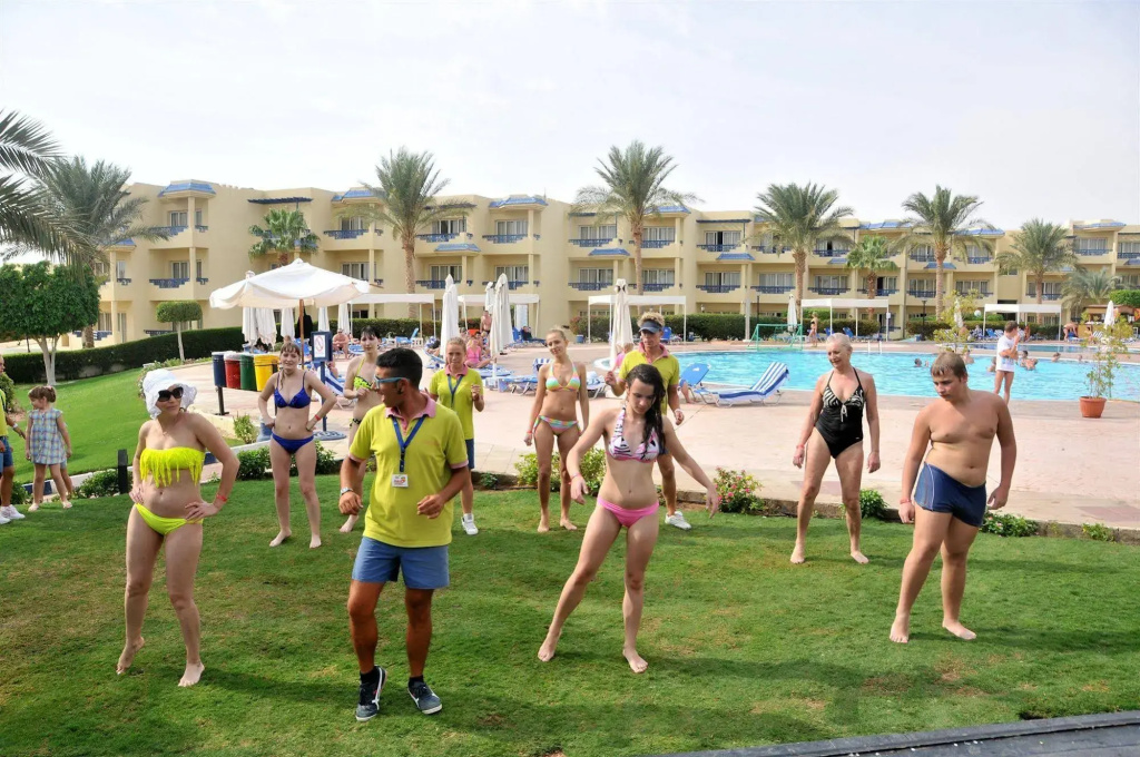 Resort Grand Oasis Resort: Guests gather for an outdoor poolside activity beside the resort swimming pool and loungers.