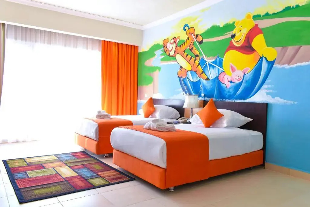 Parrotel Lagoon Waterpark Resort: A bright bedroom with two beds, colorful furnishings, and a playful sea-life mural.