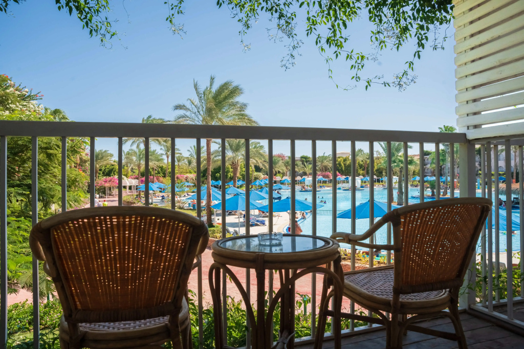 Desert Rose Resort: Relax on the furnished balcony overlooking the resort pool and palm-filled grounds.