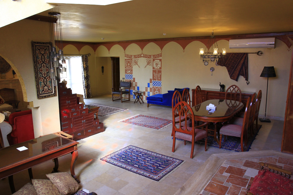 SUNRISE Garden Beach Resort: An ornate lounge and dining area with a large wooden table, upholstered seating, patterned rugs, and air conditioning.
