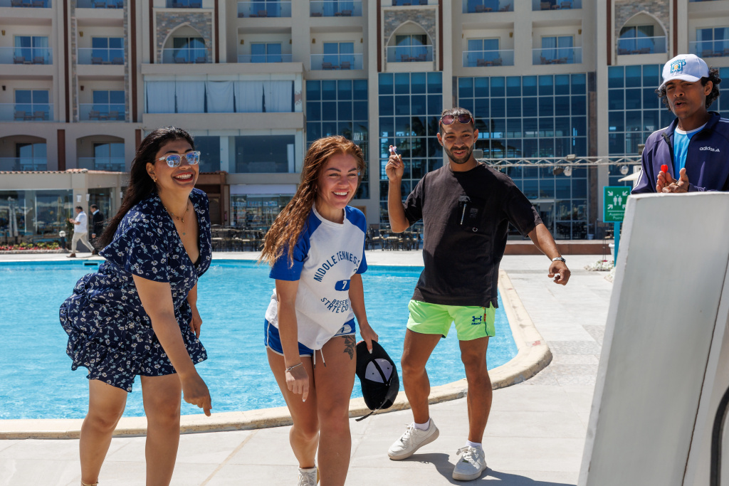 Solara Aqua Park Resort by SUNRISE: Guests gather beside the outdoor pool in front of the resort building.