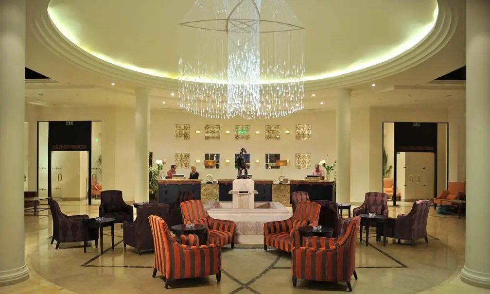 Concorde El Salam Sharm El Sheikh: A grand, warmly lit lobby with a reception desk, chandelier, and grouped lounge seating.
