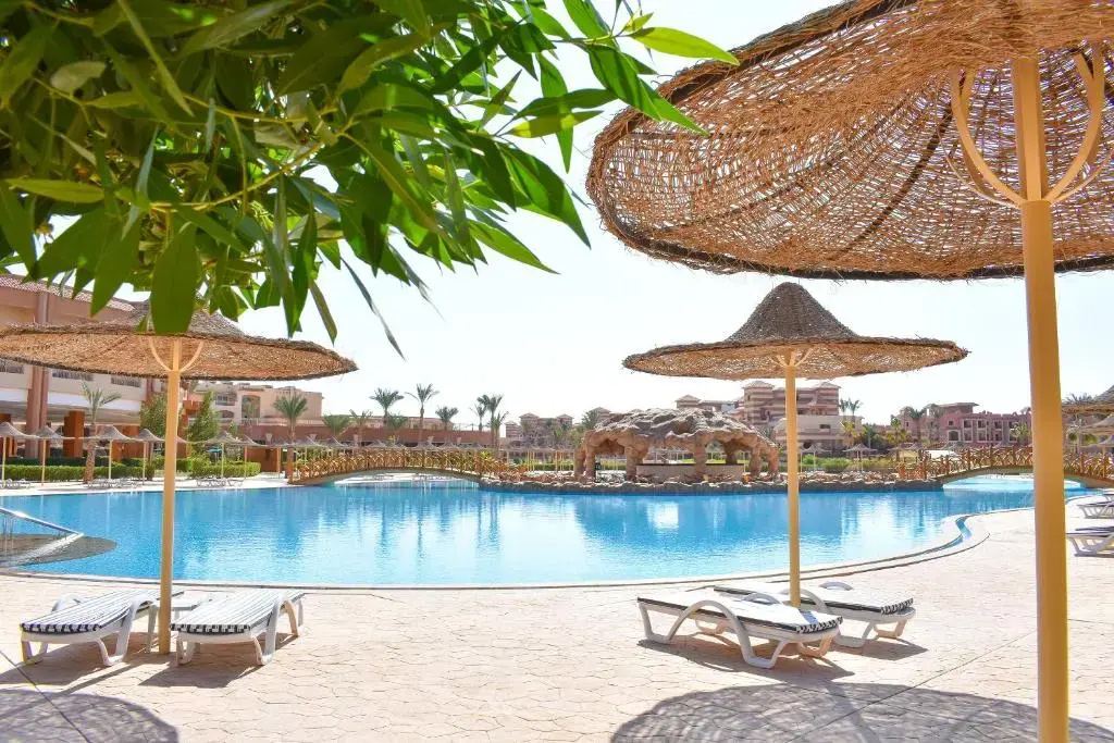 Parrotel Lagoon Waterpark Resort: Relax beside the large outdoor pool, with sun loungers and woven parasols providing shade.