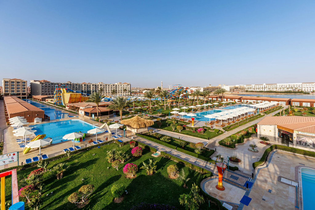 Solara Aqua Park Resort by SUNRISE: A sunny resort overview featuring multiple swimming pools, colorful water slides, and landscaped grounds with poolside loungers.