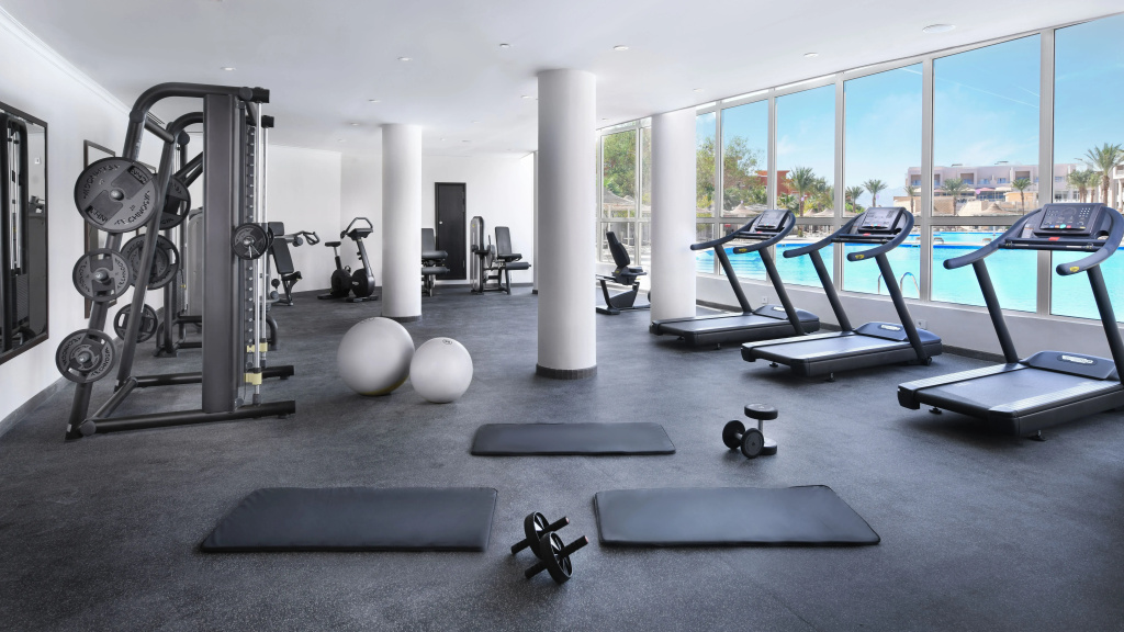 JAZ Soma Beach: Bright fitness room with treadmills, weight machines, and exercise mats beside large windows.