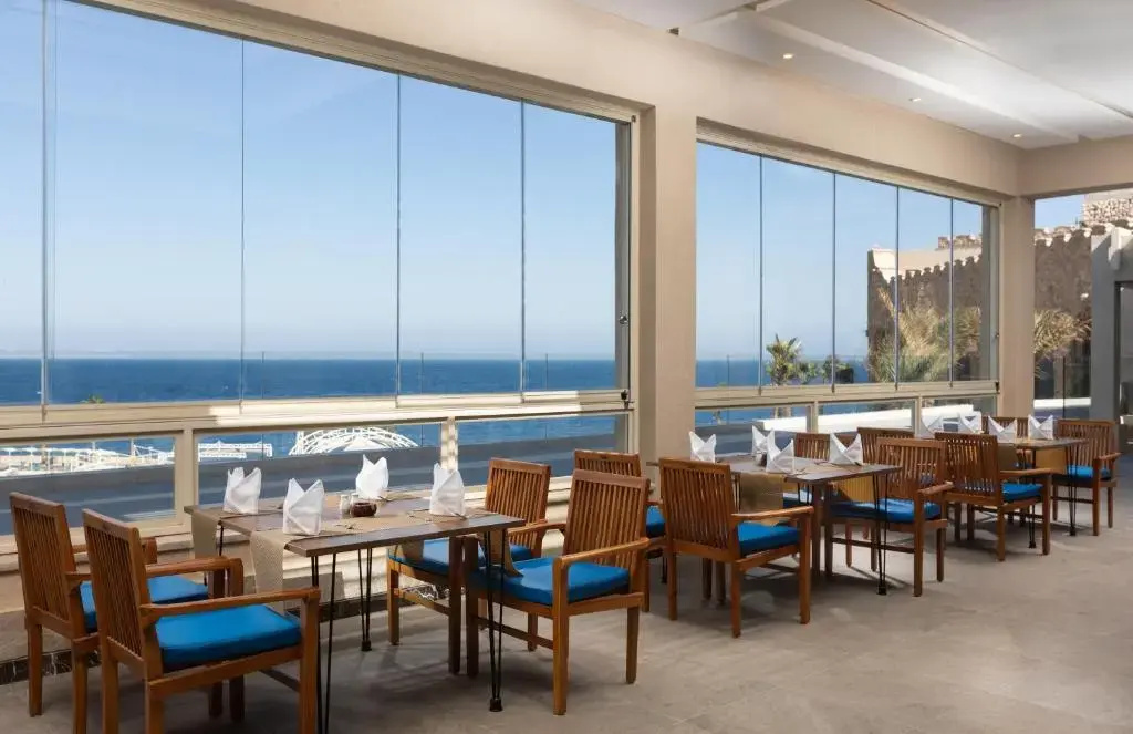 Pickalbatros Citadel Resort: Enjoy a meal in a bright dining area with expansive sea views.