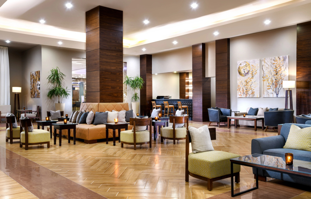 JAZ Soma Beach: A spacious hotel lobby lounge with comfortable seating, warm wood finishes, and soft lighting.