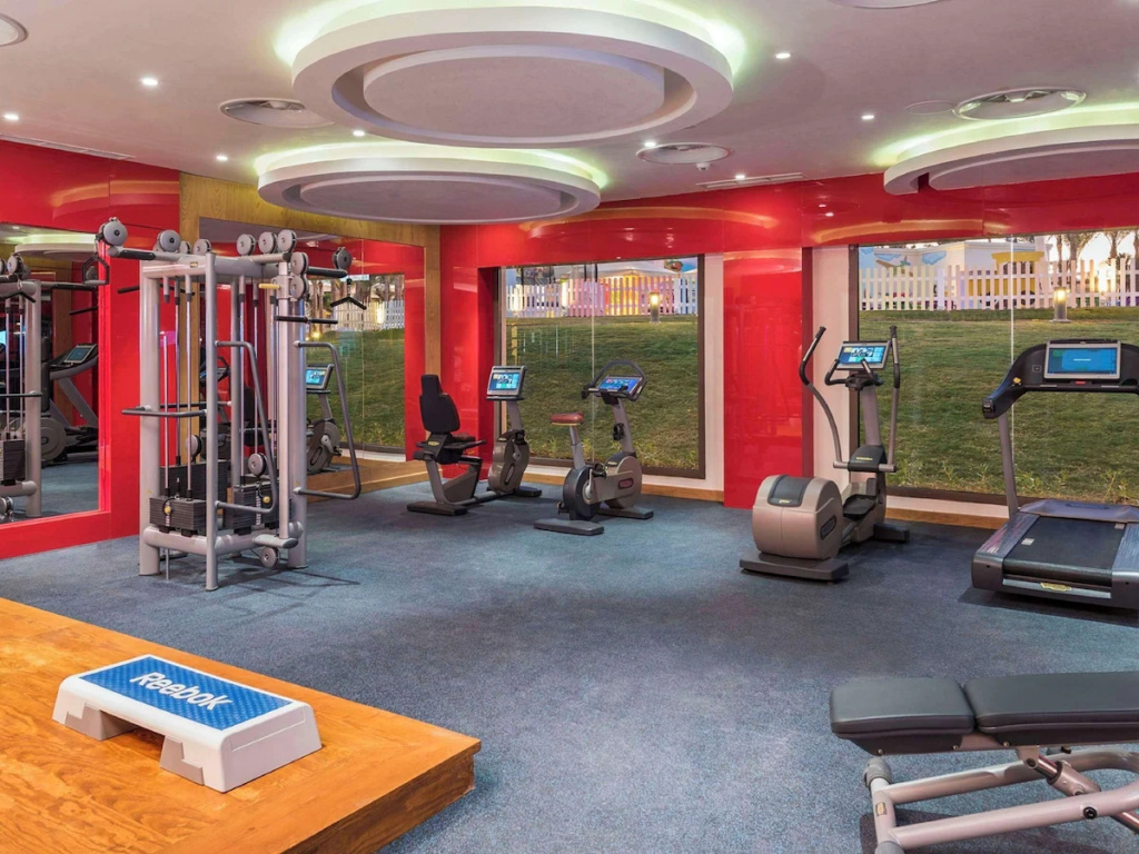 Rixos Premium Seagate: A bright fitness center with cardio machines, strength equipment, and large windows.