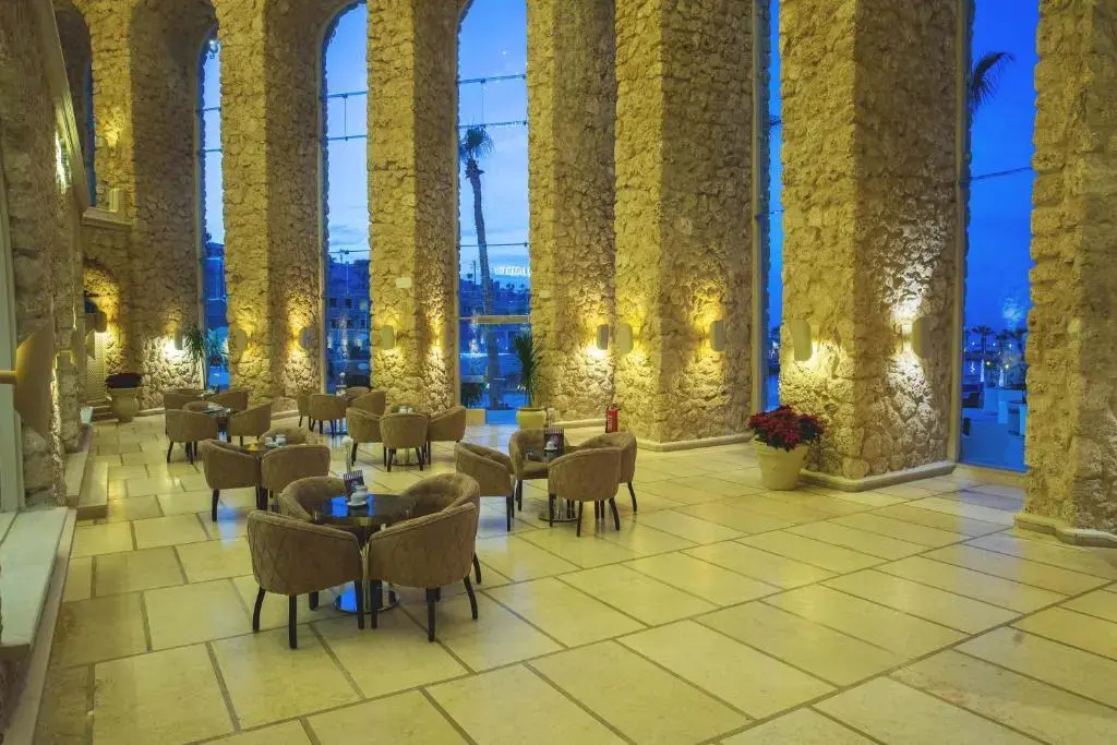 Pickalbatros Citadel Resort: A spacious stone-arched lounge with comfortable seating and tall windows.