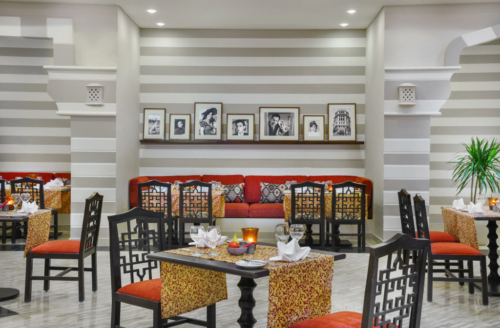 JAZ Soma Beach: A dining area with set tables, patterned décor, and a comfortable sofa seating area.