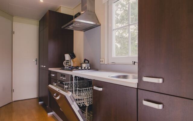 Comfy chalet with a dishwasher, directly on a pond