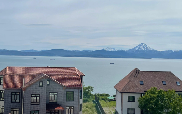 Okeanskie Panoramy. Vid na okean, vulkan, buhtu, gory i gorod Flat