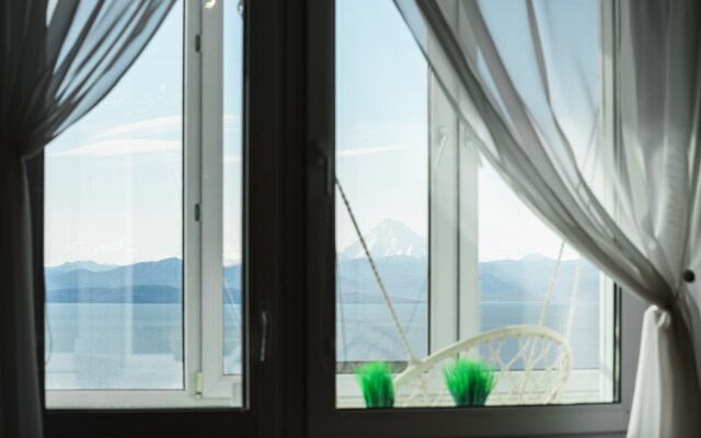 Okeanskie Panoramy. Vid na okean, vulkan, buhtu, gory i gorod Flat