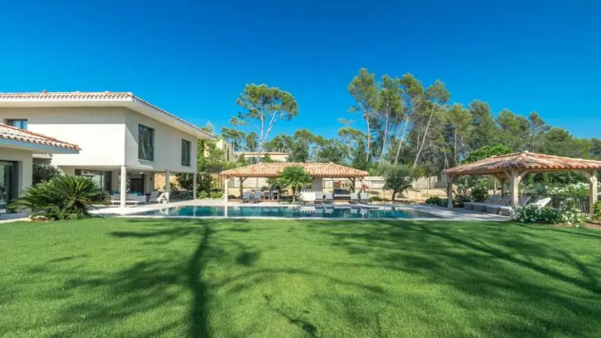 A large table with chairs and a garden furniture with sunbeds
