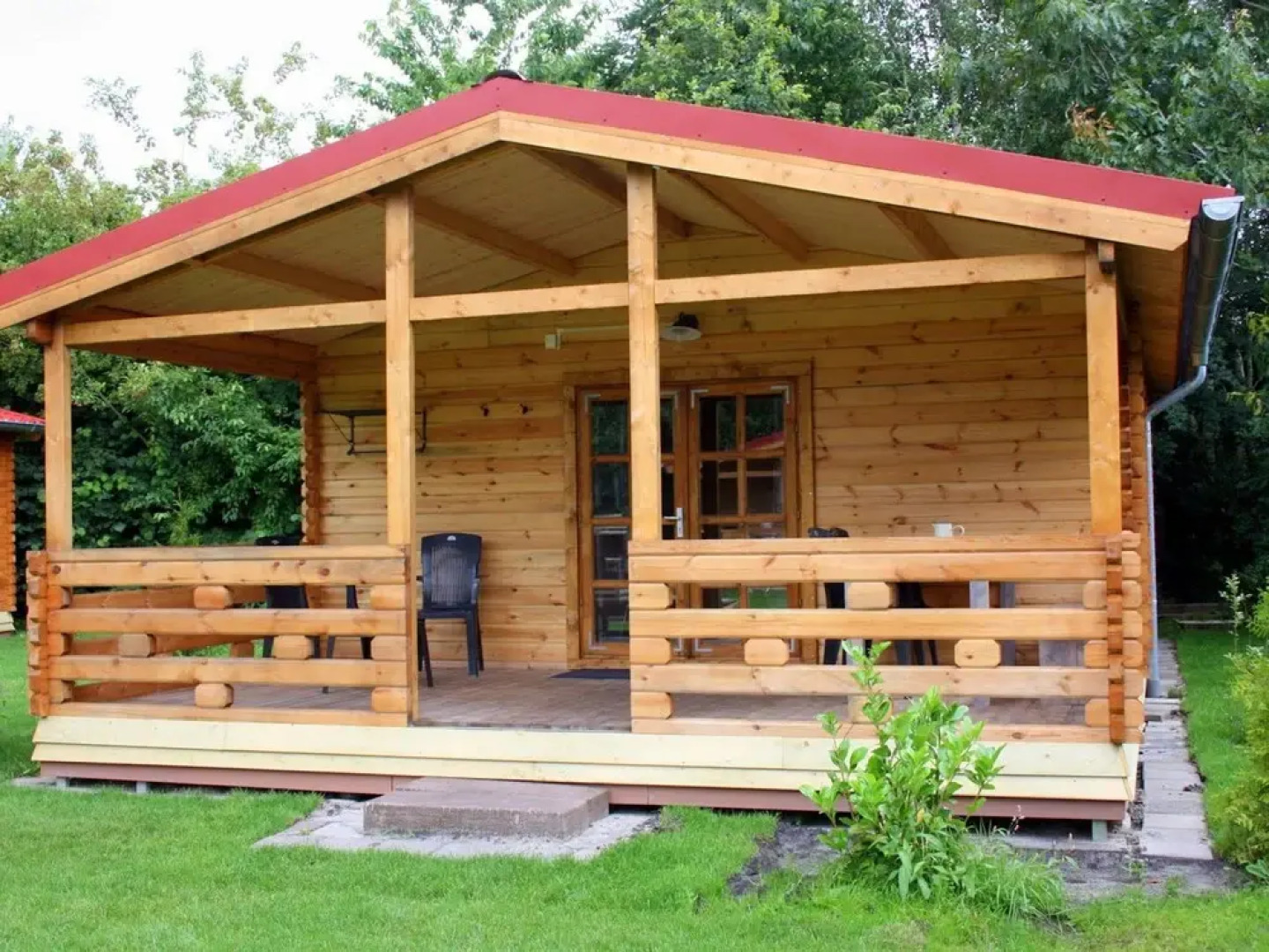 Wooden Cottage With a Veranda Located in a Natural Area