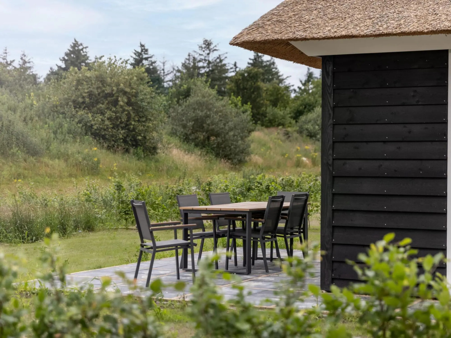 Thatched villa with sauna, in a holiday park surrounded by nature
