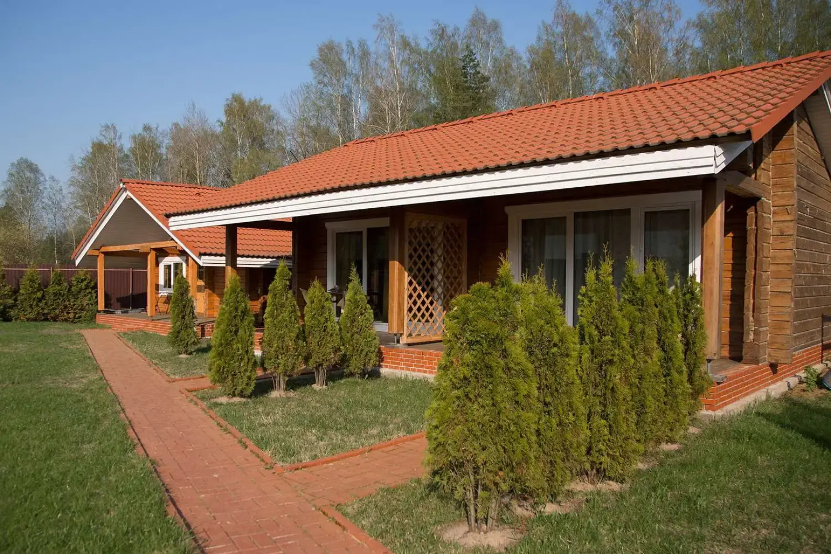 Частный дом на ухоженном участке с газоном и туями