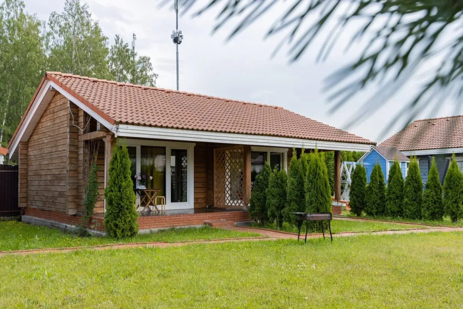 Частный дом на ухоженном участке с газоном и туями