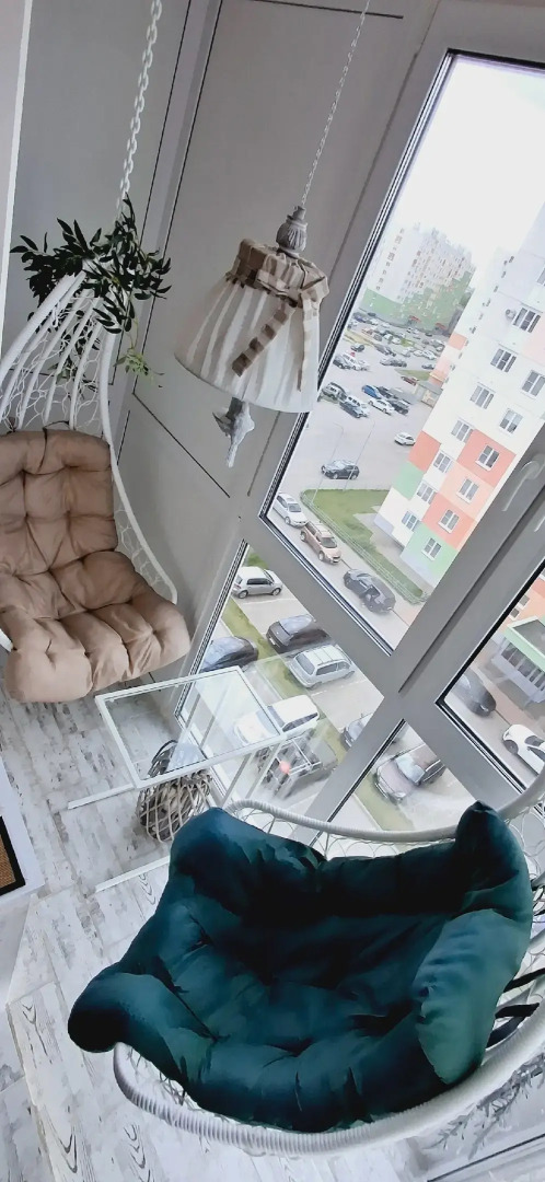 Квартира с подвесными креслами из ротанга на панорамной лоджии