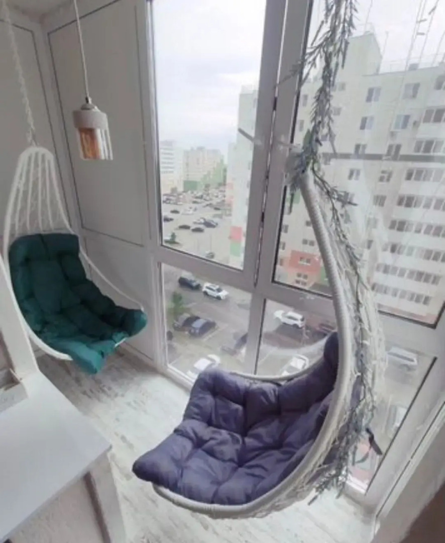 Квартира с подвесными креслами из ротанга на панорамной лоджии