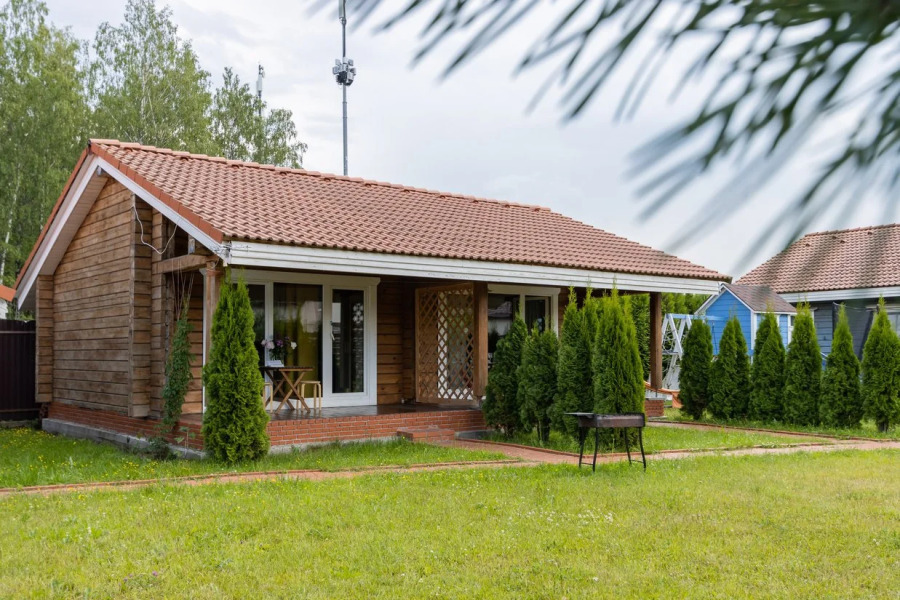 Частный дом на ухоженном участке с газоном и туями